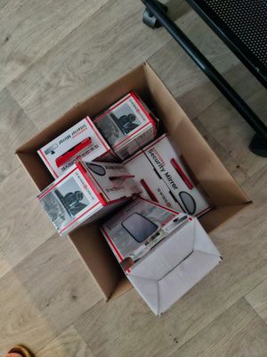 a box full of electronics on the floor next to a person ' s feet