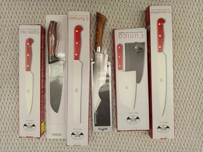 trois couteaux sont posés dans une boîte sur une surface blanche
