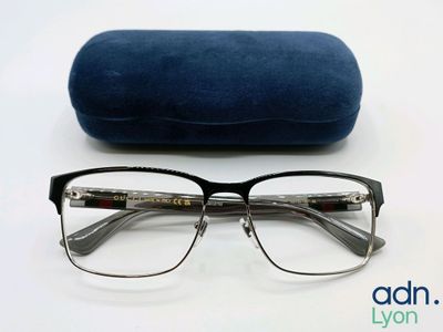 les lunettes se trouvent à côté d'un étui bleu, posées sur une surface blanche