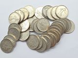 a pile of silver coins on a white surface