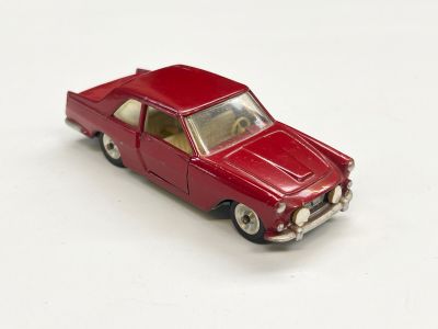 une petite voiture rouge posée sur une surface blanche