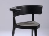 La chaise est en bois et son assise est noire.