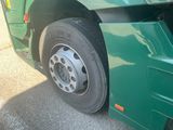 a green bus that has a flat tire on it