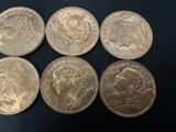 six different british coins are shown in a row on a black surface