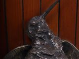 a statue of a bird sitting on top of a wooden table