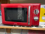 a red microwave sitting on top of a wooden shelf