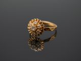 a close up of a gold ring with diamonds on a reflective surface