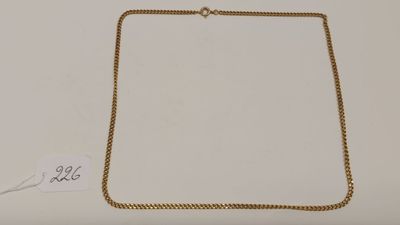un collier en or avec une chaîne sur un fond blanc
