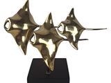 a gold sculpture of three stingfishs sitting on top of a black stand