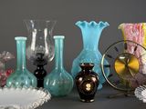 many different colored vases and a clock on the table