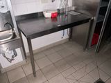 une cuisine équipée d'une table en inox et d'un évier