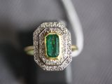 a close up of a diamond and emerald ring