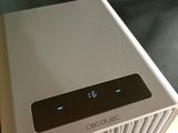 a white air conditioner sitting on top of a wooden table