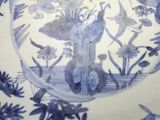 a blue and white plate with birds and flowers on it