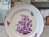 a plate with a purple design on it sitting on a table