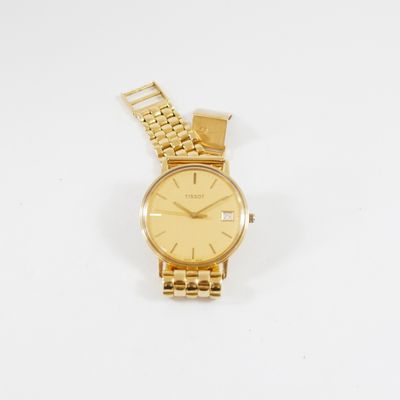 gros plan d'une montre-bracelet en or sur une surface blanche