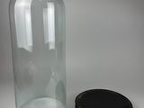 a large glass bottle with a lid next to a small plastic container
