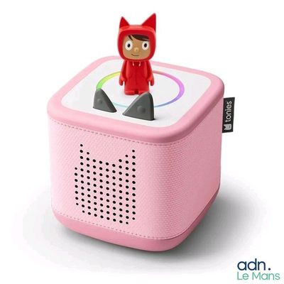 une petite enceinte rose sur laquelle est posé un chat