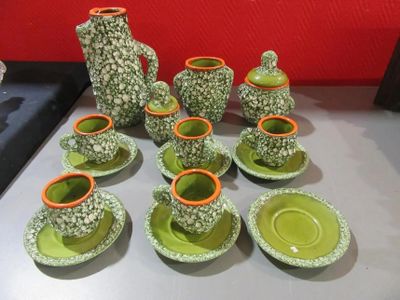 de nombreuses tasses et soucoupes vertes et orange posées sur une table