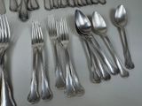 many spoons and forks laid out on the table