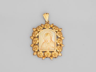 un pendentif plaqué or représentant une femme entourée d'une couronne de fleurs