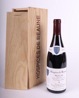 a bottle of red wine in front of a wooden box