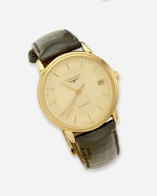 une montre-bracelet en or avec un bracelet en cuir marron