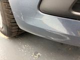 a close up of a car ' s front bumper with scratches