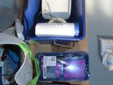 a table with a laptop, a cell phone, and other items on it