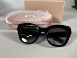 black cat eye sunglasses with pink case on a white table