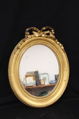 a mirror with a bow around it on a table