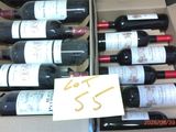 plusieurs bouteilles de vin dans un carton muni d'une étiquette de prix