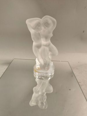 une figurine en verre posée sur une table en verre