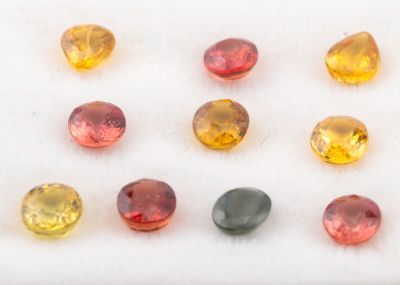 un ensemble de pierres précieuses de différentes couleurs posées sur une surface blanche