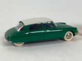 a green toy car with a white top on a white surface