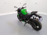 a green motorcycle that is parked in a white room
