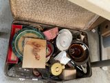 une valise remplie d'objets posée par terre