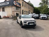 the small car is parked in front of the building in the parking lot