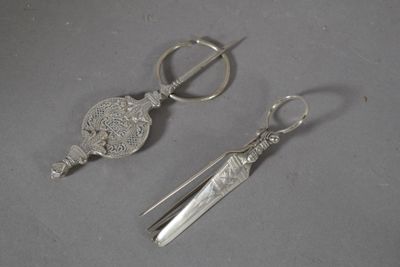 deux paires de ciseaux et une paire de ciseaux posés sur une table