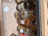many bottles of alcohol in a cabinet with labels on them