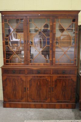 un vaisselier en bois avec des portes vitrées et un tapis