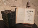 several old books are sitting on a table next to a knife