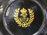 a black plate with a gold emblem on it