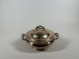 an antique silver plate covered casserole on a white background