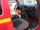 a red truck with the door open and the driver ' s seat up