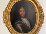 a painting of a man in a gold frame hanging on a wall