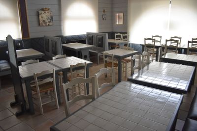 de nombreuses tables et chaises dans un restaurant doté de nombreuses fenêtres