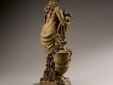 statue of a woman holding a vase with flowers in it