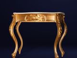 a gold console table with a lion head on the top