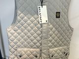 gilet matelassé gris exposé dans un magasin, muni d'une étiquette de prix